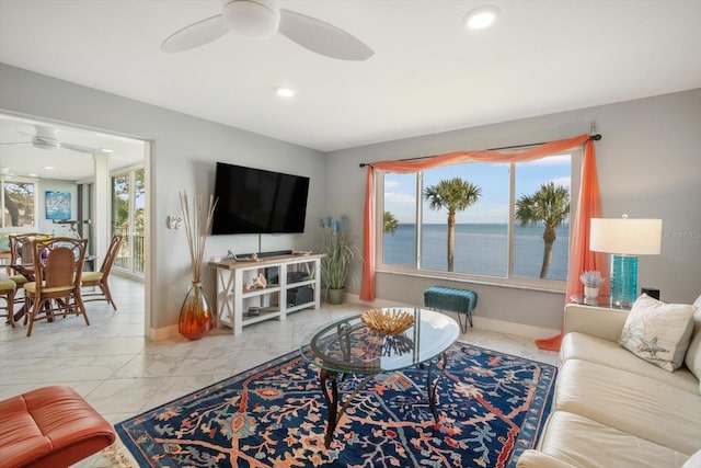 living area with baseboards, a ceiling fan, recessed lighting, and marble finish floor
