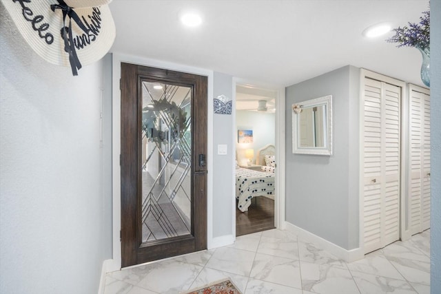 foyer with baseboards, recessed lighting, and marble finish floor