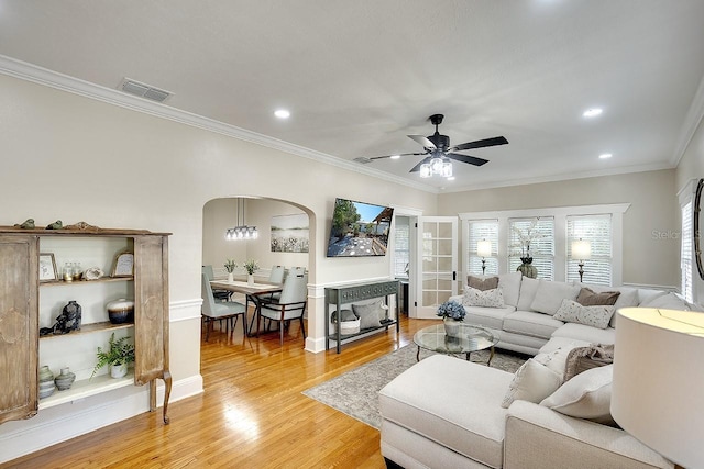 1814 6th Ave W, Bradenton, FL 34205 - living area featuring visible vents, a ceiling fan, crown molding, light wood-style floors, and arched walkways