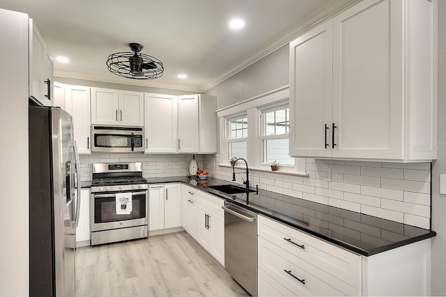 1814 6th Ave W, Bradenton, FL 34205 - kitchen with crown molding, a sink, stainless steel appliances, white cabinetry, and tasteful backsplash