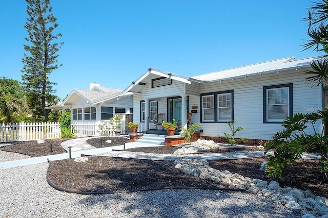 1814 6th Ave W, Bradenton, FL 34205 - rear view of house with a porch, fence, and metal roof