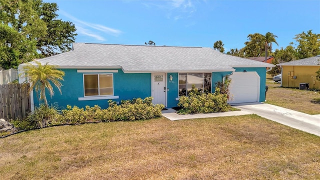 ranch-style home with fence, a garage, driveway, roof with shingles, and a front lawn