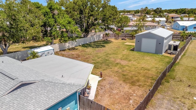 view of yard with an outdoor structure, a residential view, a fenced backyard, and central AC unit