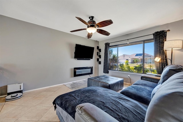 living room with light tile patterned flooring, ceiling fan, and baseboards
