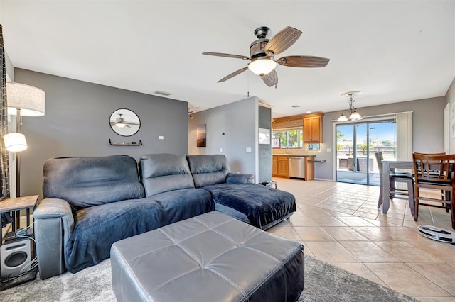living area featuring light tile patterned flooring, ceiling fan, and visible vents