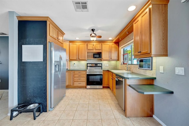 kitchen with a sink, light tile patterned floors, tasteful backsplash, visible vents, and appliances with stainless steel finishes