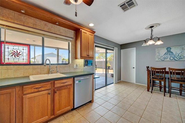 kitchen featuring decorative backsplash, a sink, visible vents, dishwasher, and ceiling fan with notable chandelier