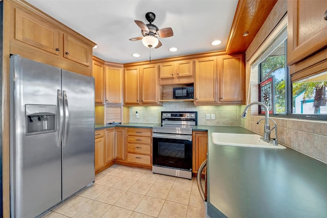 kitchen with light tile patterned floors, tasteful backsplash, a sink, appliances with stainless steel finishes, and a ceiling fan
