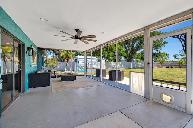 unfurnished sunroom featuring a ceiling fan