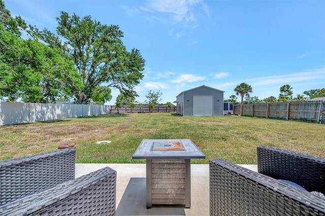view of yard with a fire pit, a patio, an outbuilding, a storage shed, and a fenced backyard