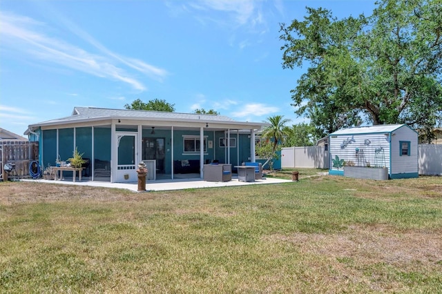 back of property featuring a storage unit, an outbuilding, a sunroom, a yard, and a fenced backyard