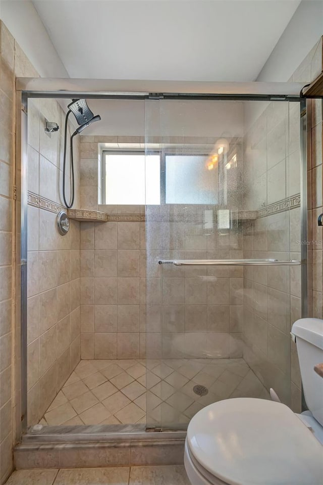 full bath with toilet and a stall shower