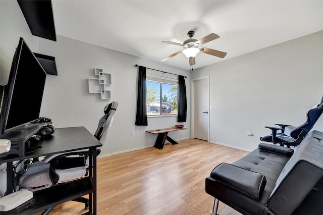 office area featuring light wood finished floors, ceiling fan, and baseboards