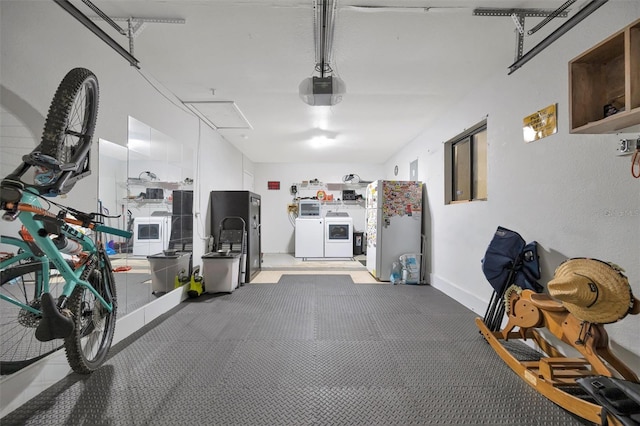 garage with a garage door opener, separate washer and dryer, refrigerator, and freestanding refrigerator