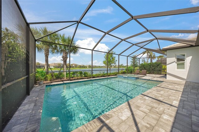 view of swimming pool featuring glass enclosure, a water view, a pool with connected hot tub, and a patio area