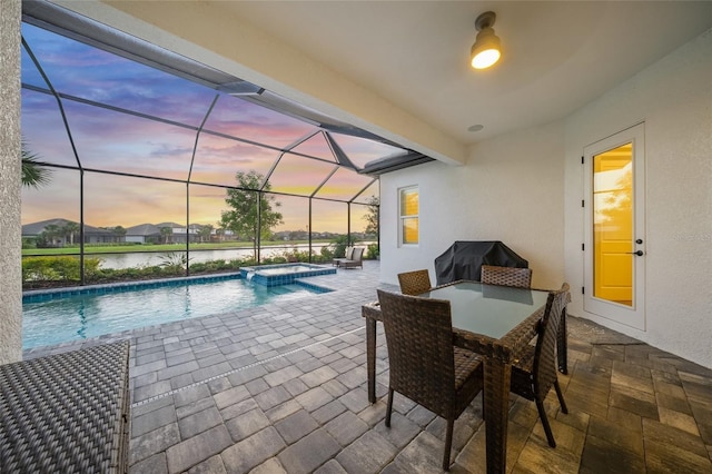 pool at dusk with a water view, a patio area, a lanai, and a pool with connected hot tub
