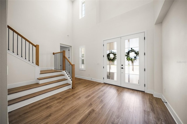 entrance foyer featuring french doors, wood finished floors, a healthy amount of sunlight, and stairway