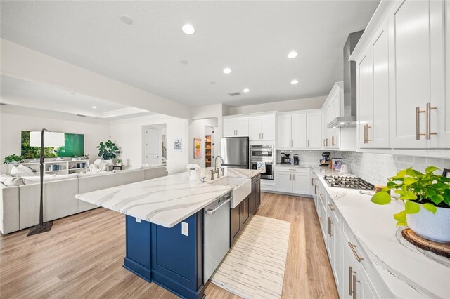 kitchen with appliances with stainless steel finishes, a sink, white cabinetry, recessed lighting, and tasteful backsplash