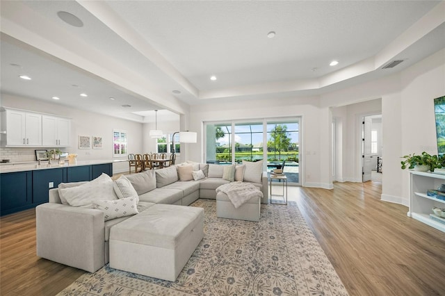 living room featuring visible vents, recessed lighting, light wood-style floors, and plenty of natural light