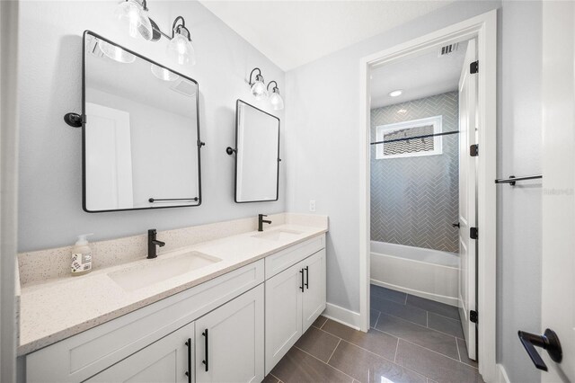 full bath featuring a sink, baseboards, tile patterned floors, and double vanity