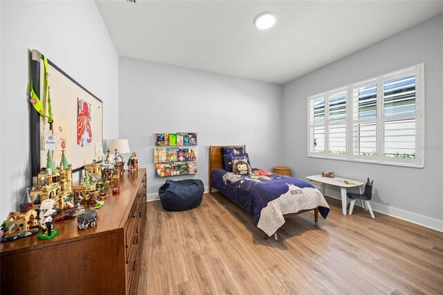 bedroom with baseboards and wood finished floors
