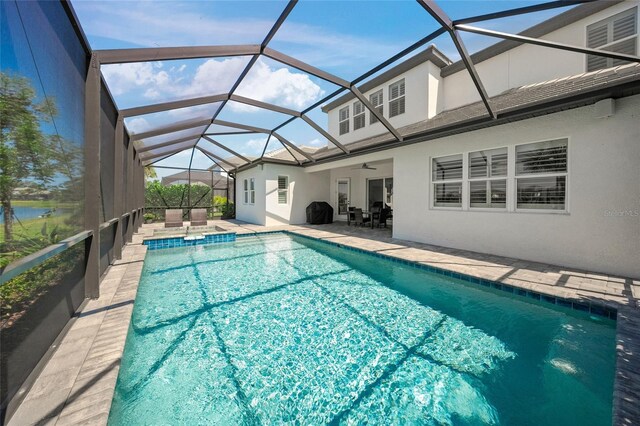 view of swimming pool featuring a patio, ceiling fan, and a lanai