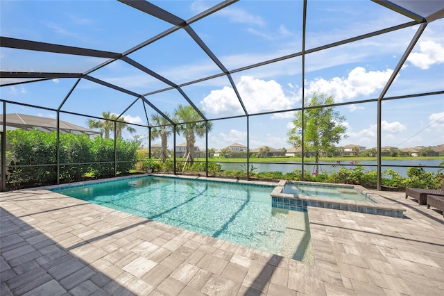 view of pool featuring glass enclosure, a water view, a pool with connected hot tub, and a patio area