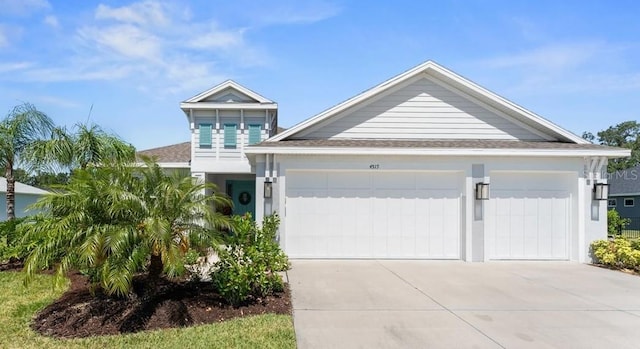 view of front of home with driveway, a shingled roof, and a garage