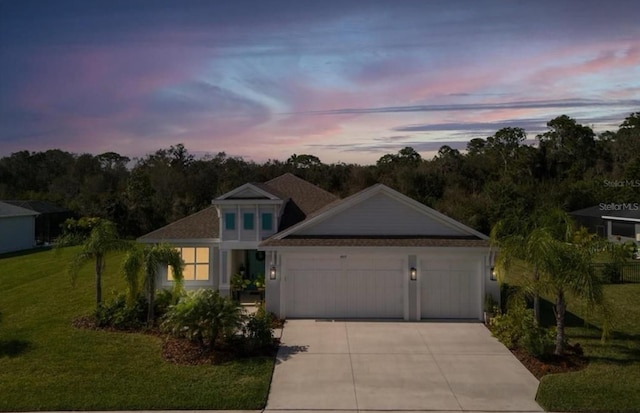 view of front of house with concrete driveway, a front lawn, and a garage
