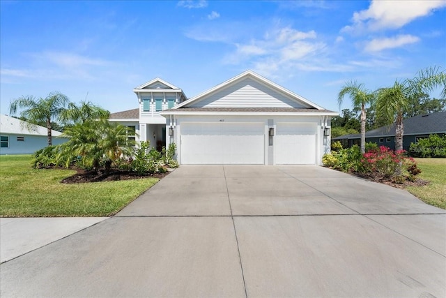 view of front of house with a garage, concrete driveway, and a front lawn