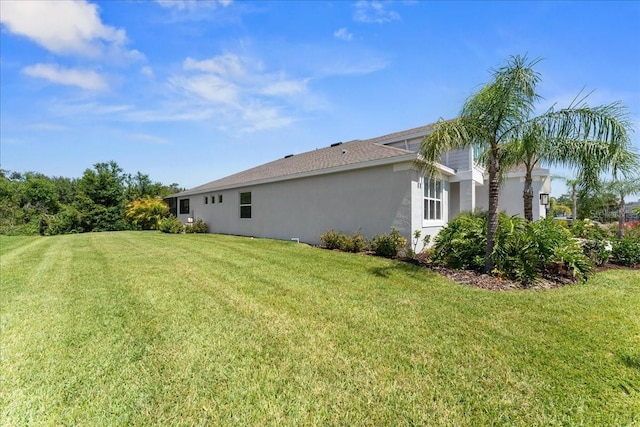 back of property with a yard and stucco siding