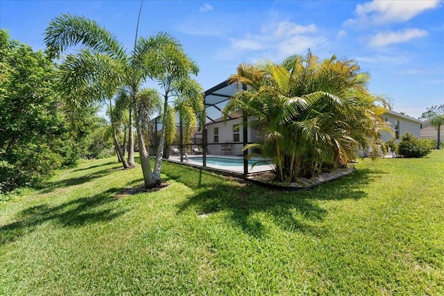 view of yard featuring glass enclosure and an outdoor pool
