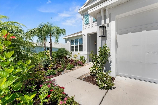doorway to property featuring a garage and stucco siding