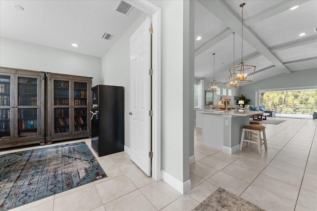 interior space featuring light tile patterned floors, vaulted ceiling with beams, a chandelier, and visible vents