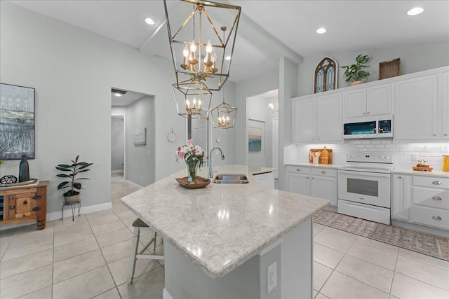 kitchen featuring a sink, light tile patterned floors, an inviting chandelier, and white appliances