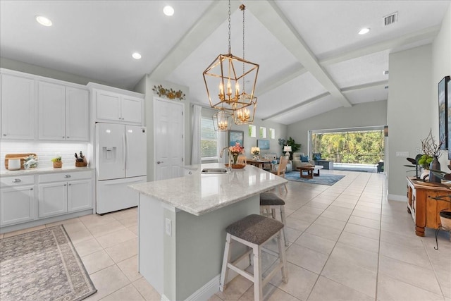 kitchen featuring visible vents, white refrigerator with ice dispenser, light tile patterned floors, a sink, and lofted ceiling with beams