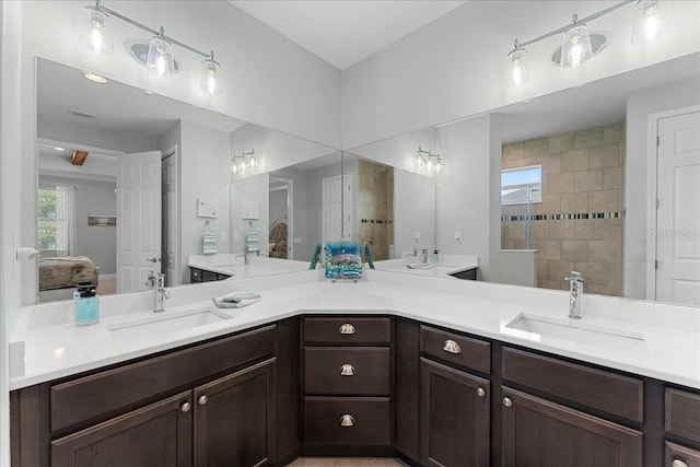 ensuite bathroom with a sink, ensuite bath, and double vanity
