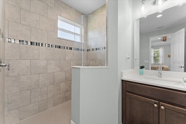 ensuite bathroom featuring a walk in shower, connected bathroom, visible vents, and vanity