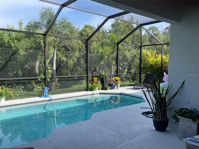 pool featuring glass enclosure and a patio