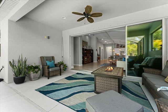 view of patio featuring ceiling fan and an outdoor living space with a fire pit