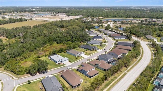 birds eye view of property featuring a water view, a view of trees, and a residential view
