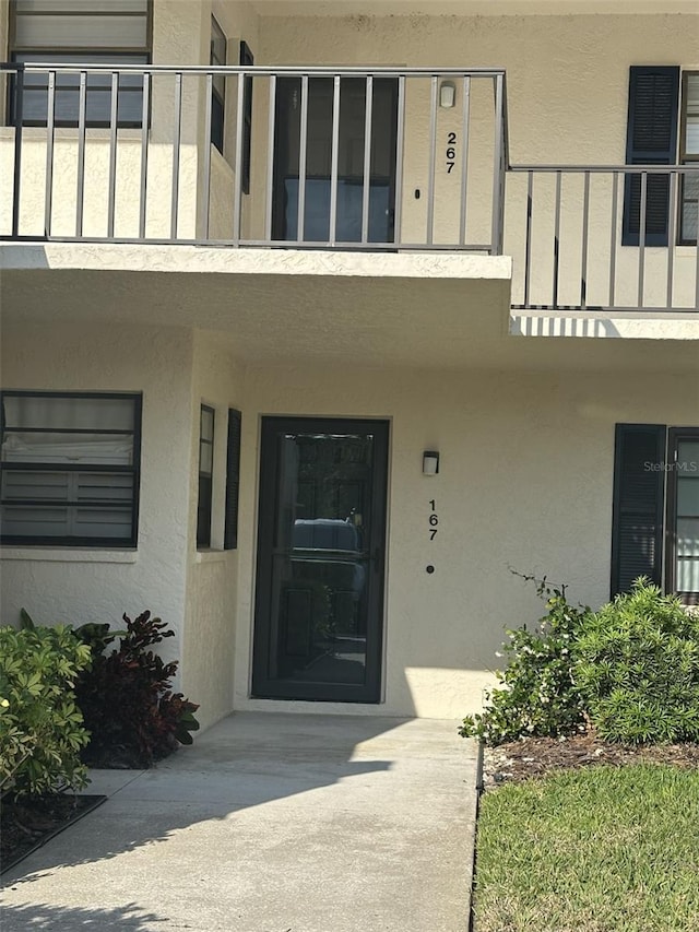 7050 Fairway Bend Ln Unit 167, Sarasota, FL 34243 - doorway to property featuring stucco siding and a balcony