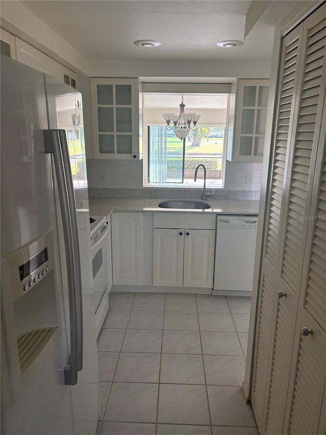 7050 Fairway Bend Ln Unit 167, Sarasota, FL 34243 - kitchen with white appliances, a sink, light countertops, decorative backsplash, and a chandelier