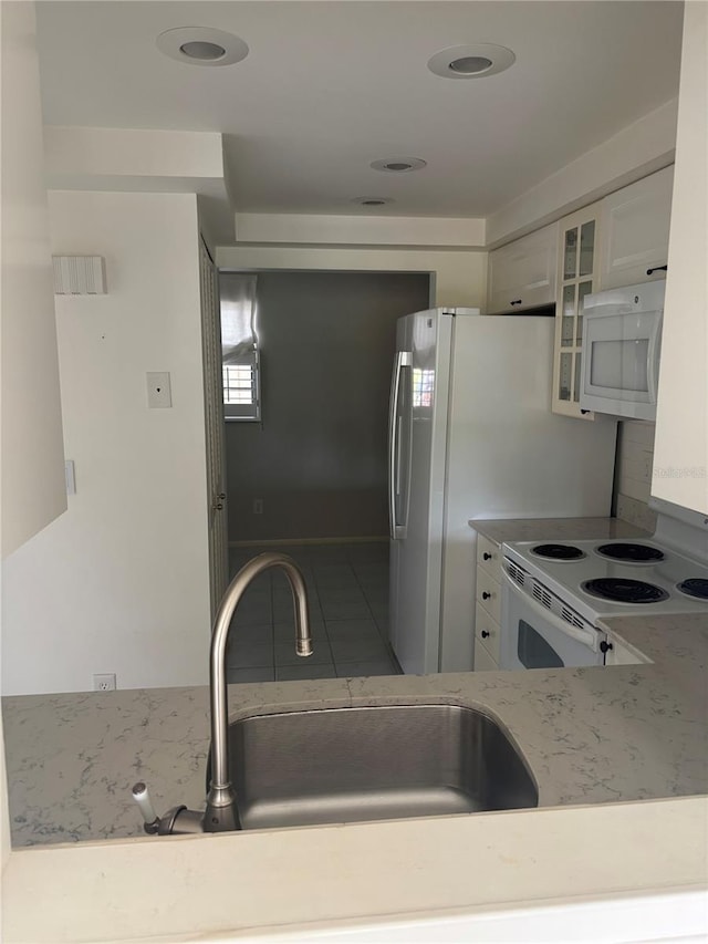 7050 Fairway Bend Ln Unit 167, Sarasota, FL 34243 - kitchen with white appliances, white cabinets, a sink, and glass insert cabinets