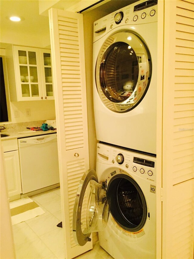 7050 Fairway Bend Ln Unit 167, Sarasota, FL 34243 - laundry area with stacked washer / dryer and light tile patterned floors