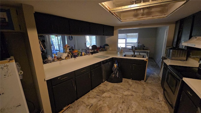 kitchen with dark cabinets, light countertops, a sink, and stainless steel range with electric cooktop