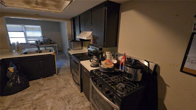 kitchen featuring stainless steel electric range, a sink, light countertops, dark cabinetry, and under cabinet range hood
