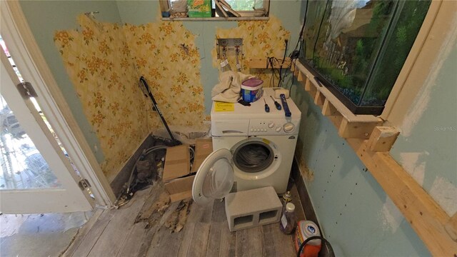 laundry area featuring laundry area, washer / clothes dryer, wood finished floors, and wallpapered walls