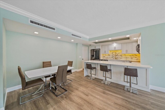 1212 Benjamin Franklin Dr Unit 306, Sarasota, FL 34236 - dining area featuring ornamental molding, light wood-style flooring, baseboards, and recessed lighting