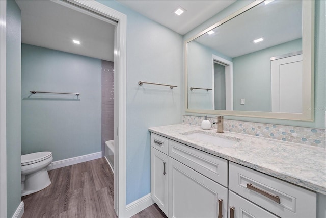 1212 Benjamin Franklin Dr Unit 306, Sarasota, FL 34236 - bathroom featuring vanity, toilet, wood finished floors, and baseboards